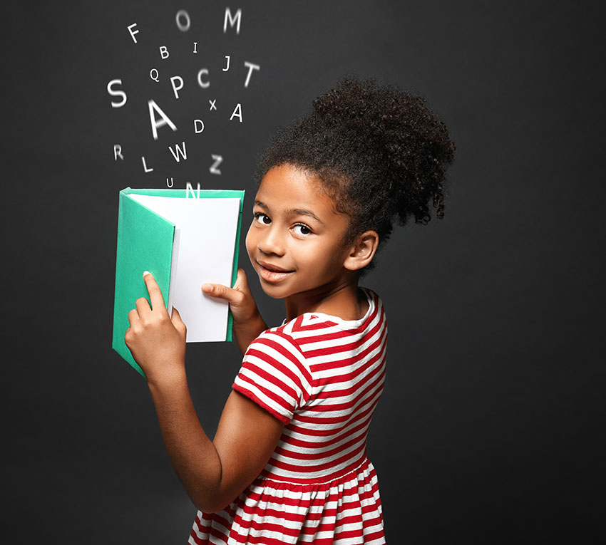 Afroamerikansk liten jente med bok- og alfabetbokstaver på mørk bakgrunn. Logopedikonsept